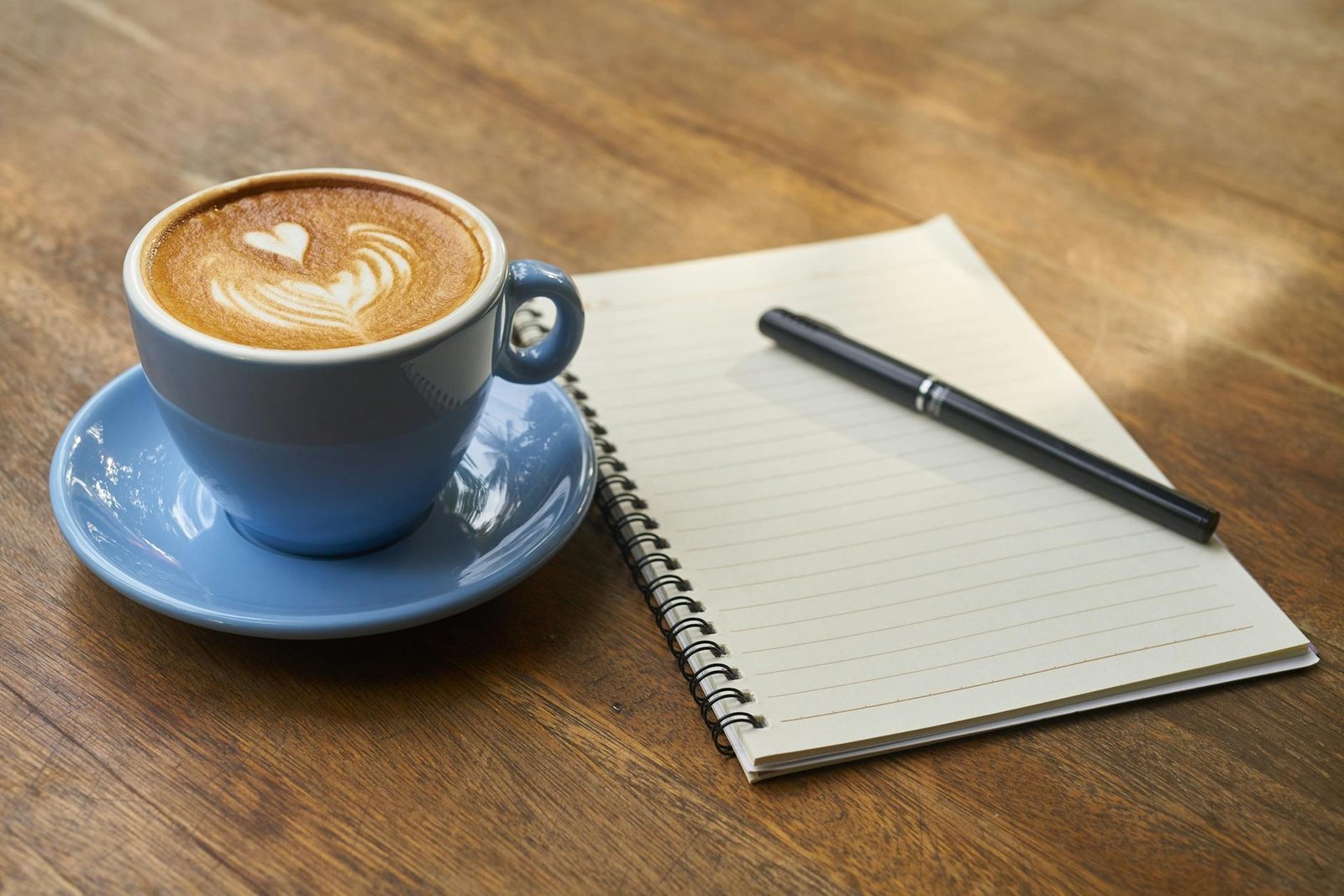 coffee on saucer beside the notebook
